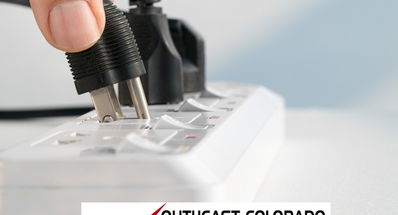 a photo of a power strip and a hand plugging in multiple appliances